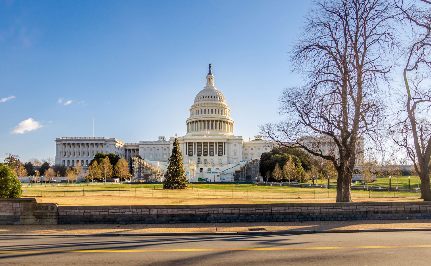 Capitol building with dome and surrounding lawn.